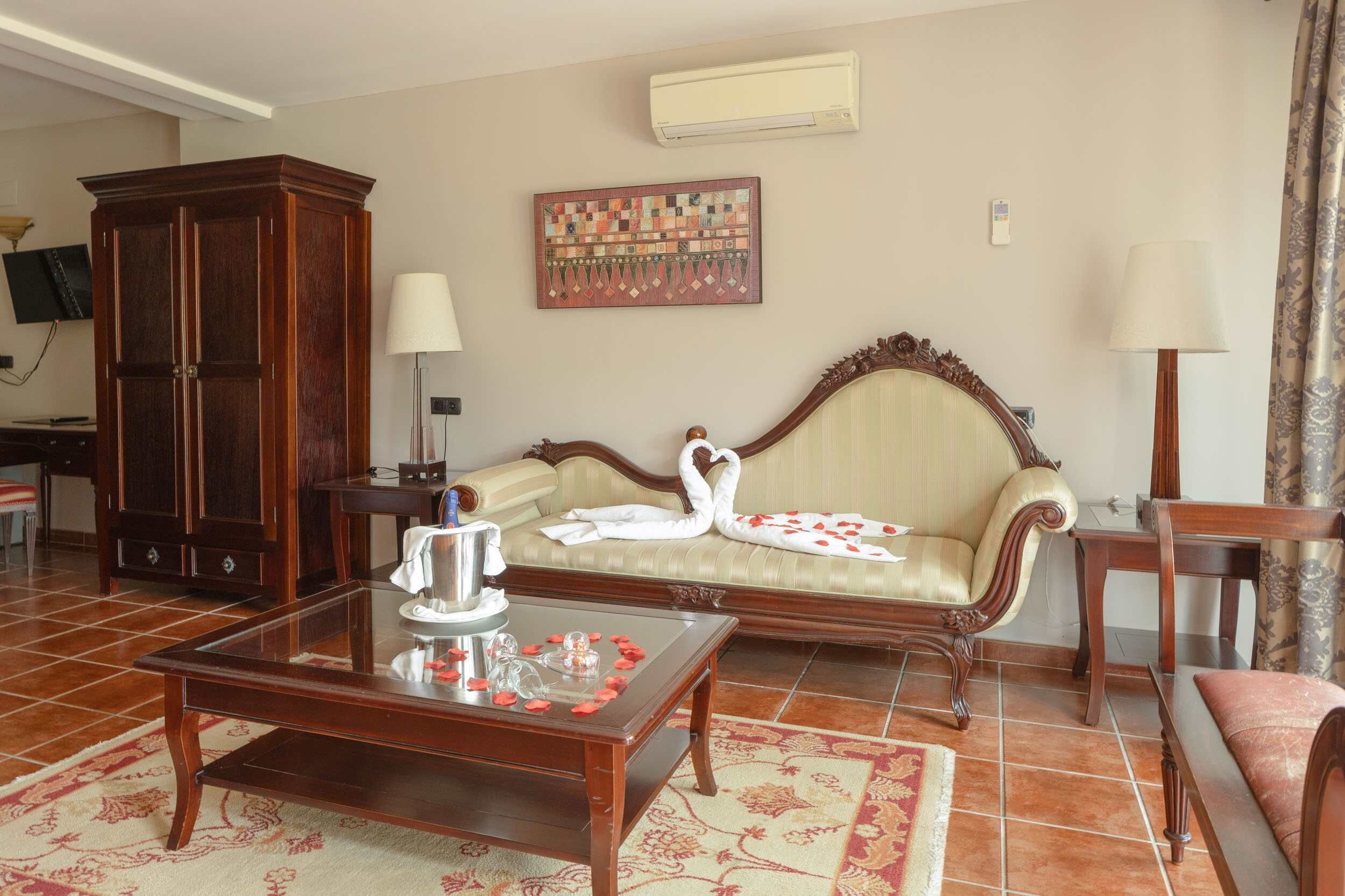 Een woonkamer met een bank, een houten kast, een salontafel en een wandairconditioner.
