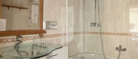Un baño con lavamanos de vidrio, inodoro, bañera y ducha.