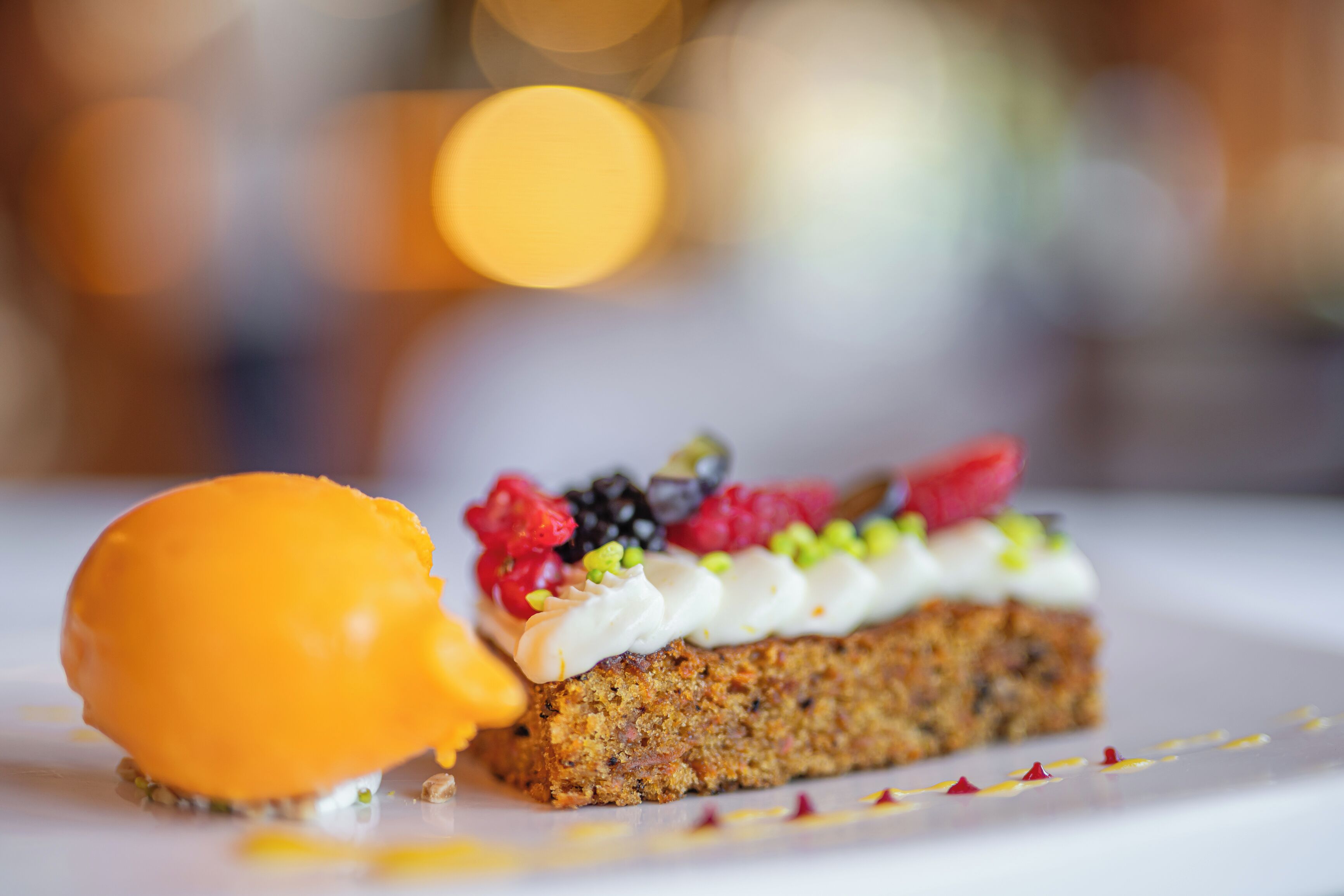 A dessert with a slice of cake topped with whipped cream and berries, and a scoop of ice cream on the side.