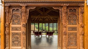 An ornately carved wooden structure with a view of a garden through large windows. - Etxegana Hotel & Spa (Zeanuri)
