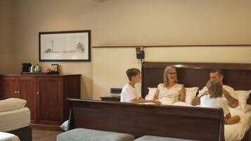 A hotel room with a bed, bedside table, and a framed picture on the wall.