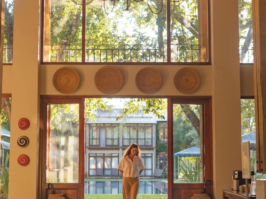 Un vestíbulo amplio con ventanas grandes, una araña de cristal y vistas al exterior.