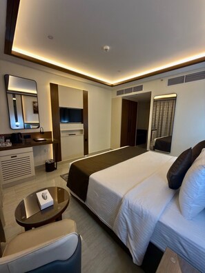 A modern hotel room with a large bed, bedside tables, a desk, a mirror, and a wardrobe. - Smana Hotel Al Raffa (Dubai)