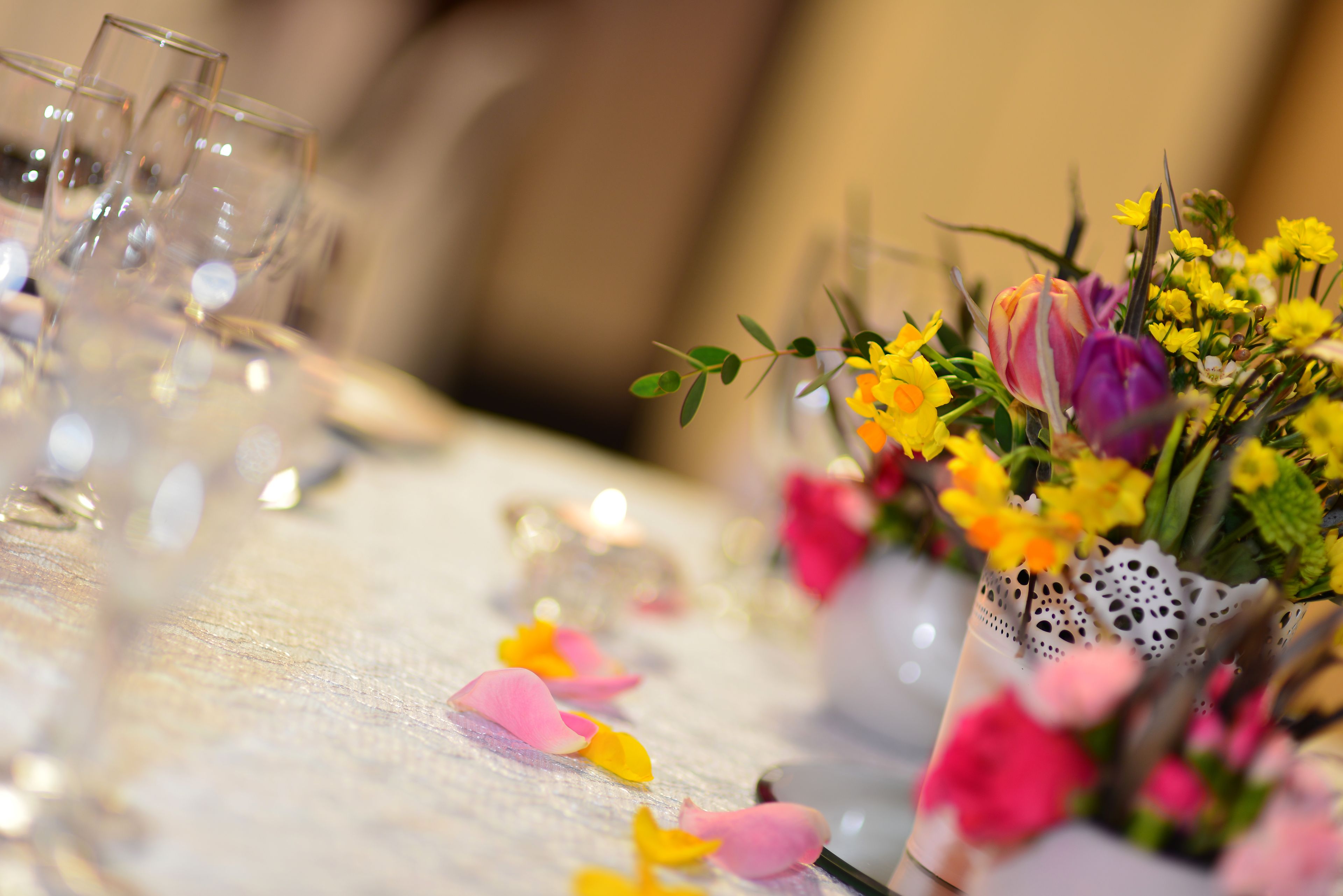 Una mesa dispuesta con vasos transparentes y un centro de mesa floral.