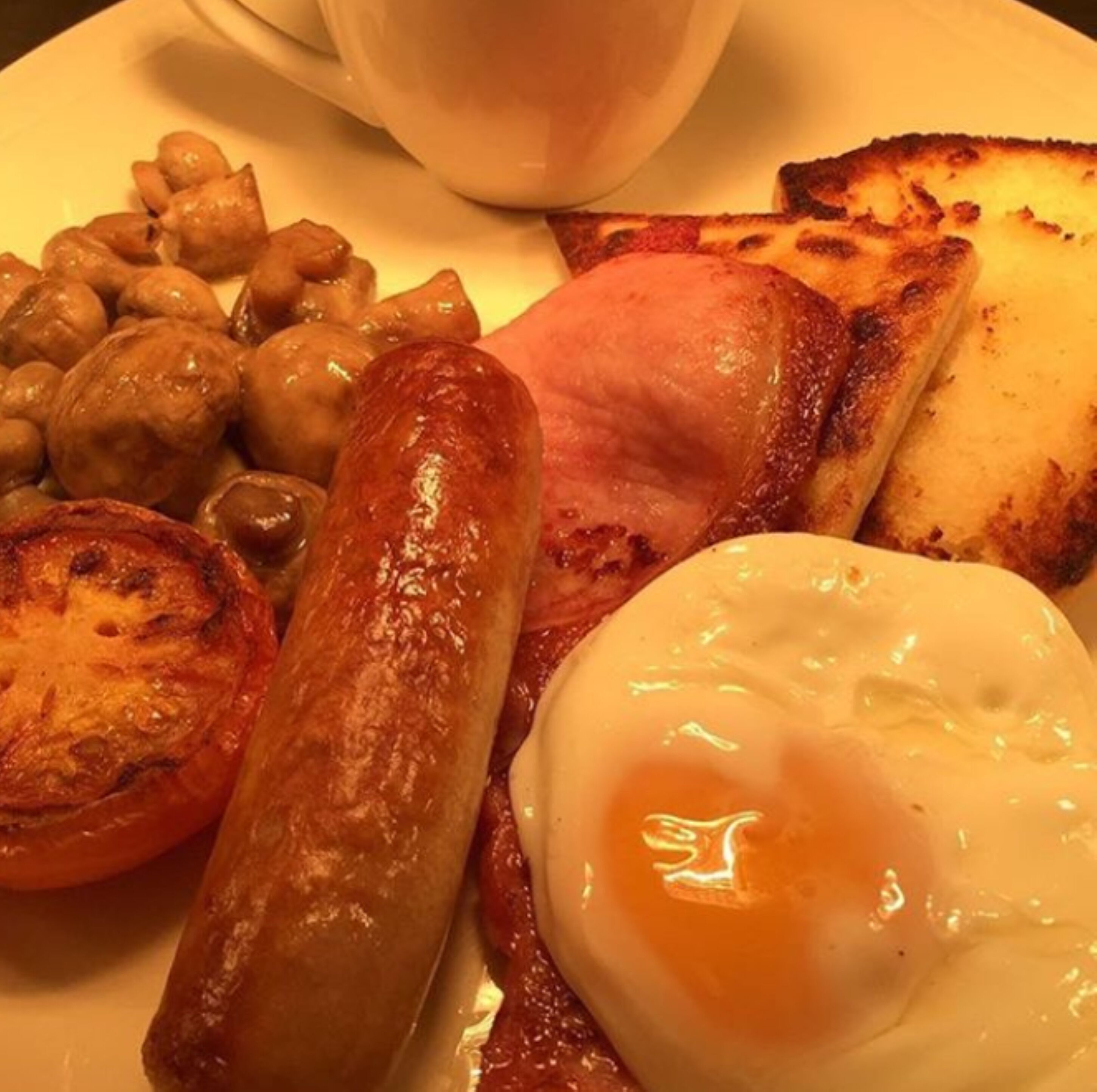 Un plato de comida para el desayuno con salchichas, huevos y tostadas.