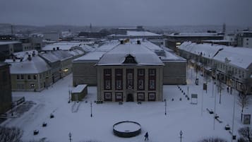A large, historic building with a symmetrical facade and a central courtyard surrounded by snow-covered streets and other buildings.
