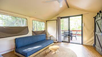 Un interior acogedor con un sofá azul, una pequeña mesa de madera y un ventilador de techo.