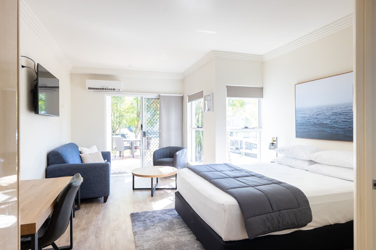 Une chambre d’hôtel moderne équipée d’un grand lit, d’un canapé, d’une table à manger et d’un téléviseur.