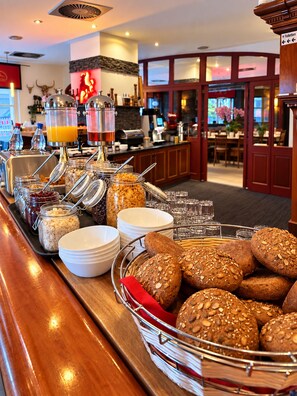 Disposición de buffet con diversos alimentos y bebidas.