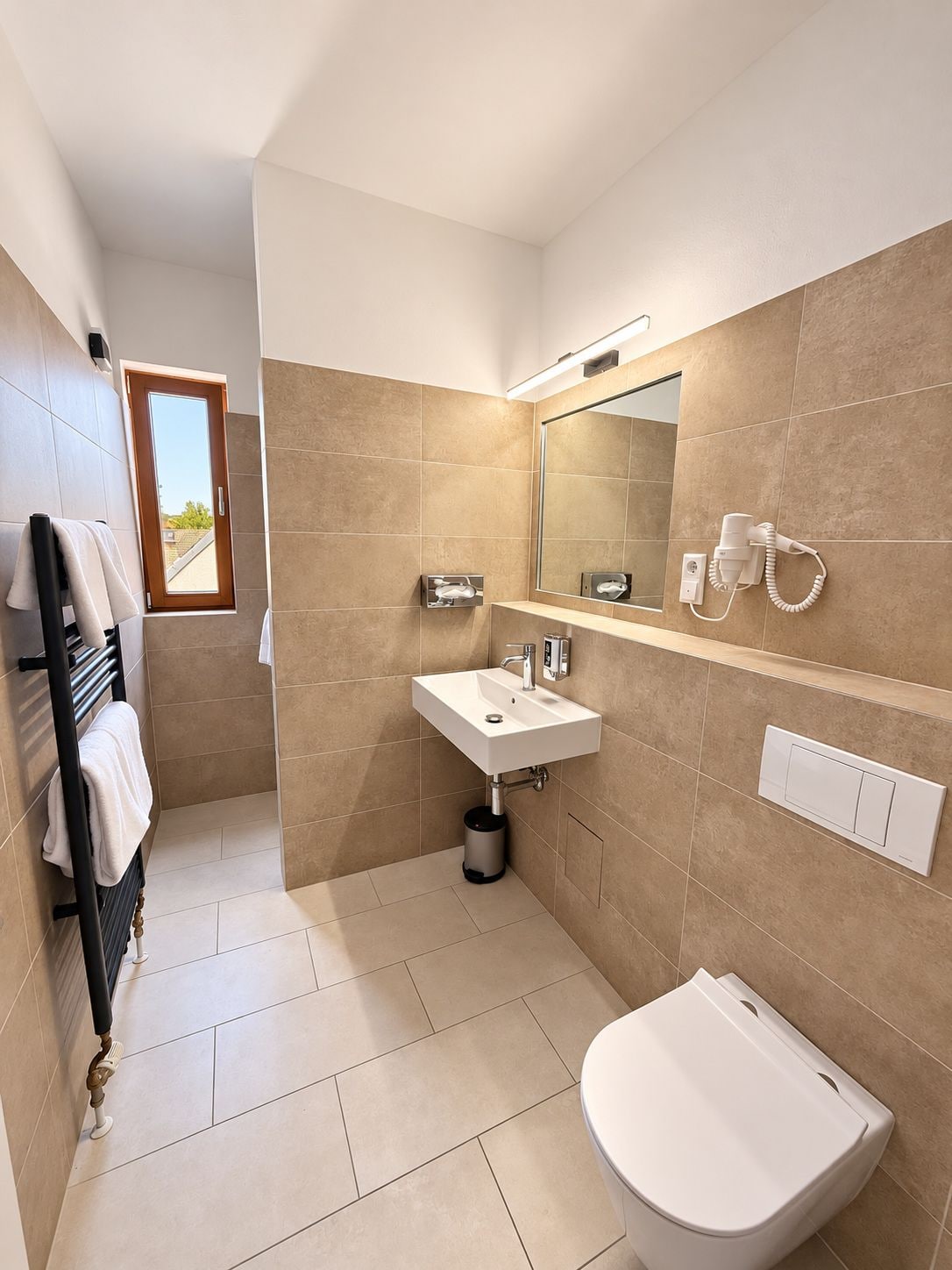 Ein modernes Badezimmer mit Waschbecken, Spiegel und Toilette.