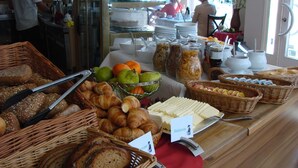 A buffet with various food items including bread, pastries, fruits, and condiments. - Altstadt Hotel (Potsdam)