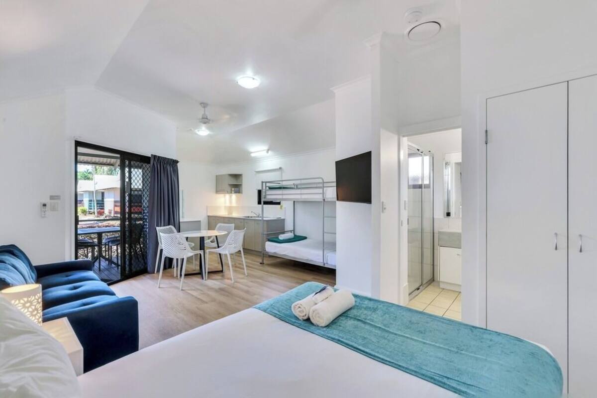 Una habitación de hotel moderna con cama, escritorio, silla y balcón.