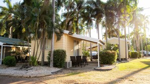 A resort with outdoor seating, palm trees, and a covered area. - Darwin FreeSpirit Resort (Holtze)