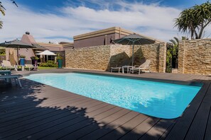 Piscine extérieure, parasols de plage, chaises longues