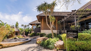 A courtyard with a fountain, lush greenery, and a 'Welcome' sign. - SW1 Lodge (Cape Town)
