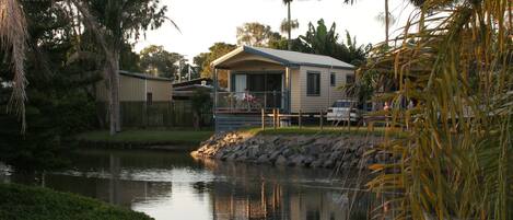 A lakeside property with a house, a dock, and surrounding greenery.