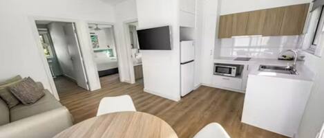 Una cocina moderna con armarios blancos, un microondas y un lavabo.