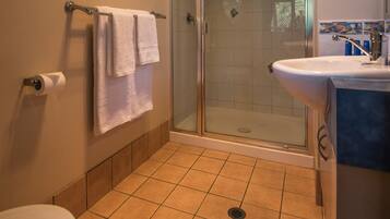 Ein Badezimmer mit Dusche, Toilette und Waschbecken.