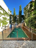 Una piscina al aire libre de temporada, sombrillas