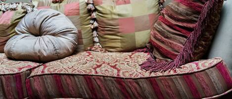 A sofa with multiple cushions in various patterns and textures.
