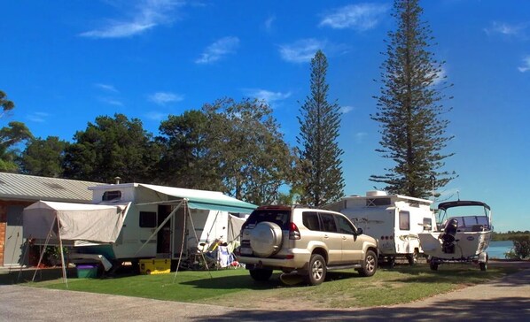 A campsite with RVs and a boat.