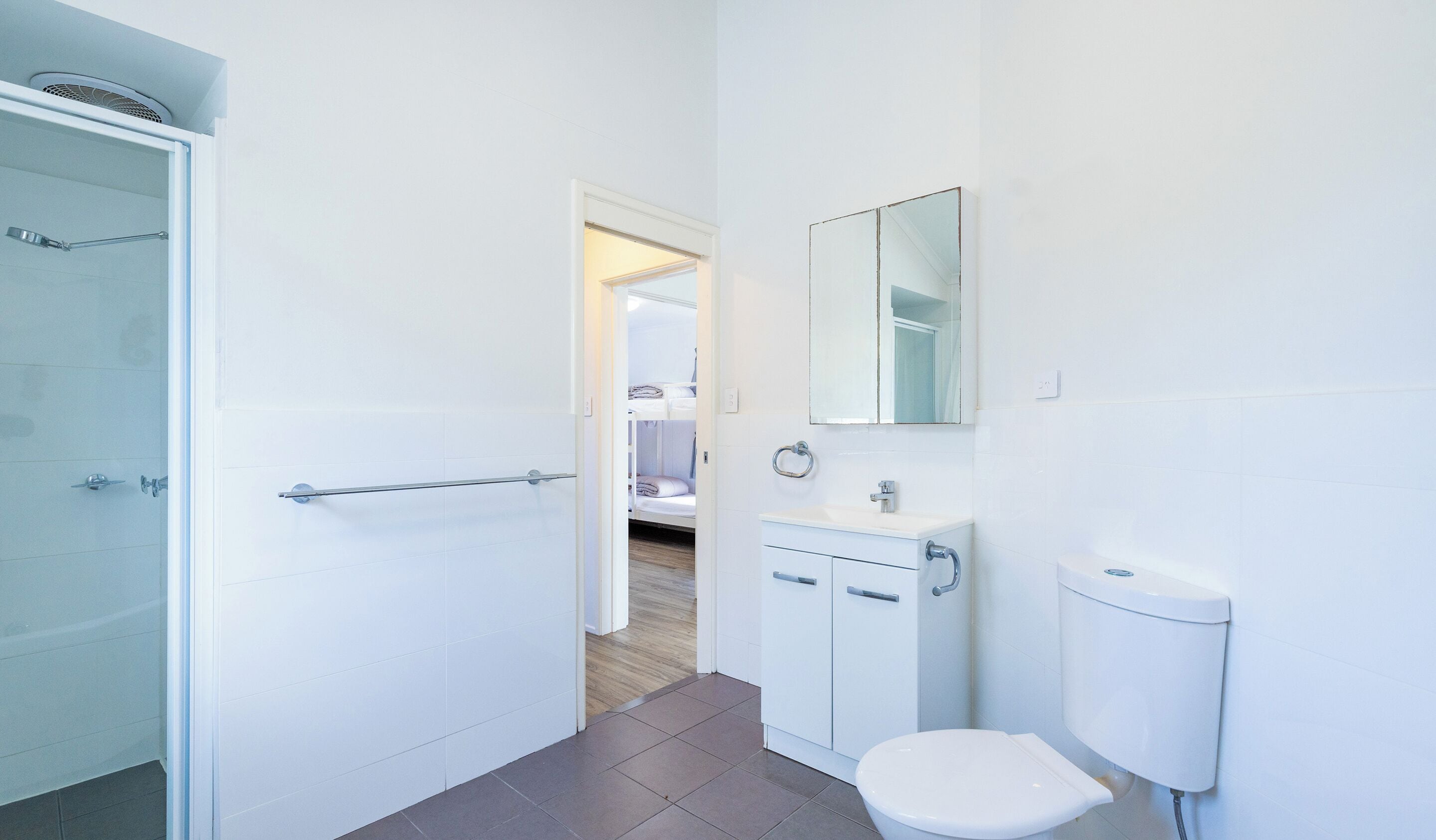 Une salle de bain équipée d’une douche, de toilettes, d’un lavabo et d’un miroir.