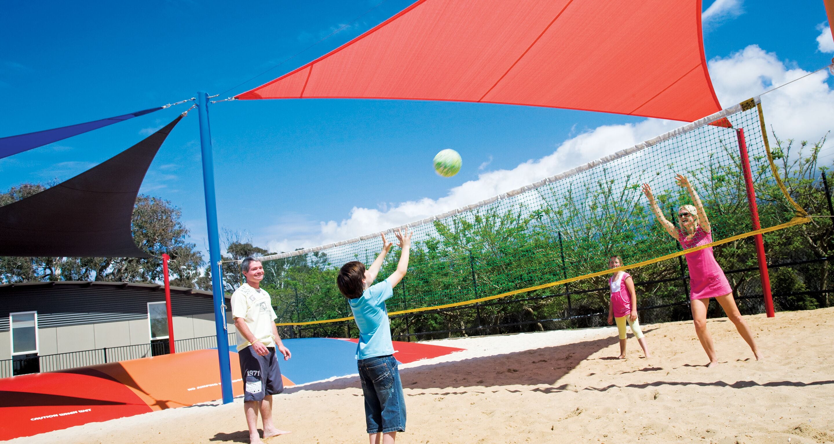 A beach volleyball game with a net and players.