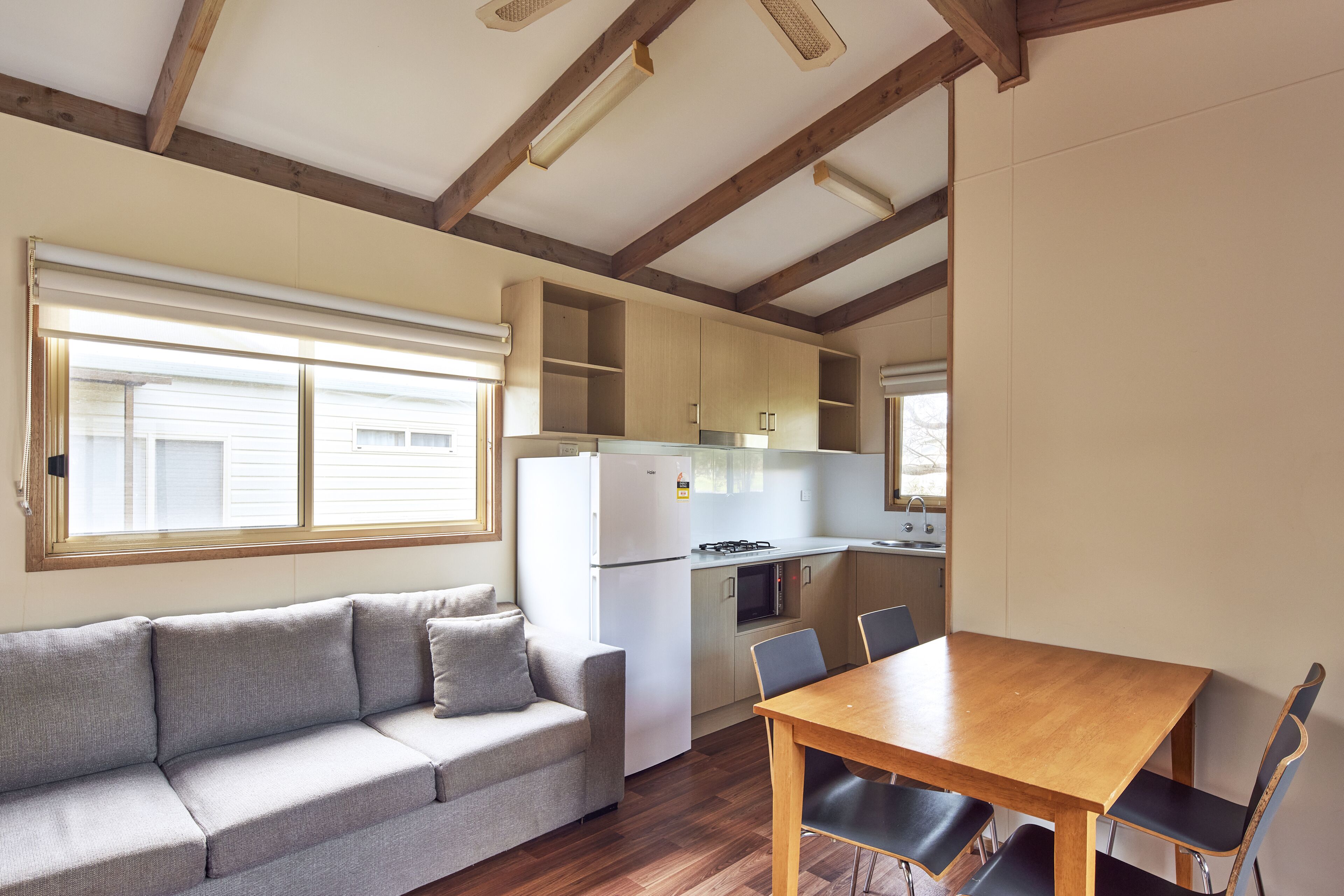 A compact living space with a sofa, dining table, and kitchenette.