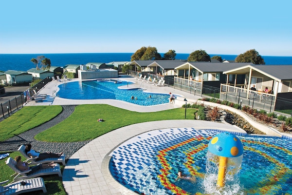 Una piscina al aire libre, sillones reclinables de piscina