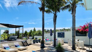A pool area with lounge chairs, a covered seating area, and a view of the surrounding landscape. - Southern Cross Guest House (Cape Town)
