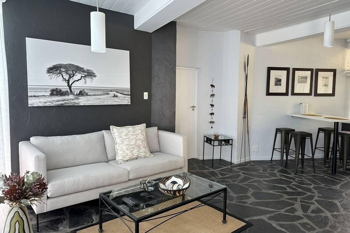 A living room with a sofa, coffee table, and artwork on the wall.
