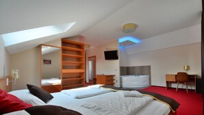 Ein Hotelzimmer mit zwei Betten, einem Schreibtisch, einem Stuhl, einem Fernseher und einer Badewanne.