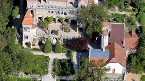 Ein Luftbild eines schlossartigen Gebäudes mit mehreren Türmen und einem Innenhof.