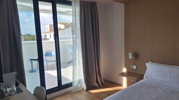 Une chambre d’hôtel avec un lit, un bureau et une vue sur l’extérieur.