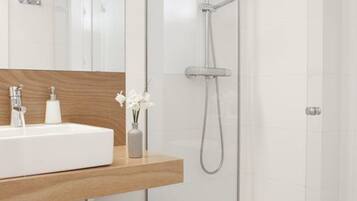 Een moderne badkamer met een glazen douchecabine, een houten wastafelmeubel en een witte wastafel.