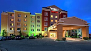 Monikerroksinen Fairfield Inn & Suites by Marriott -hotelli, jonka edessä on parkkipaikka.