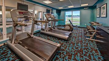 A fitness center with treadmills, a rowing machine, and a weight bench area.