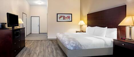 A hotel room with a bed, bedside lamps, a television, and a small desk with a lamp.