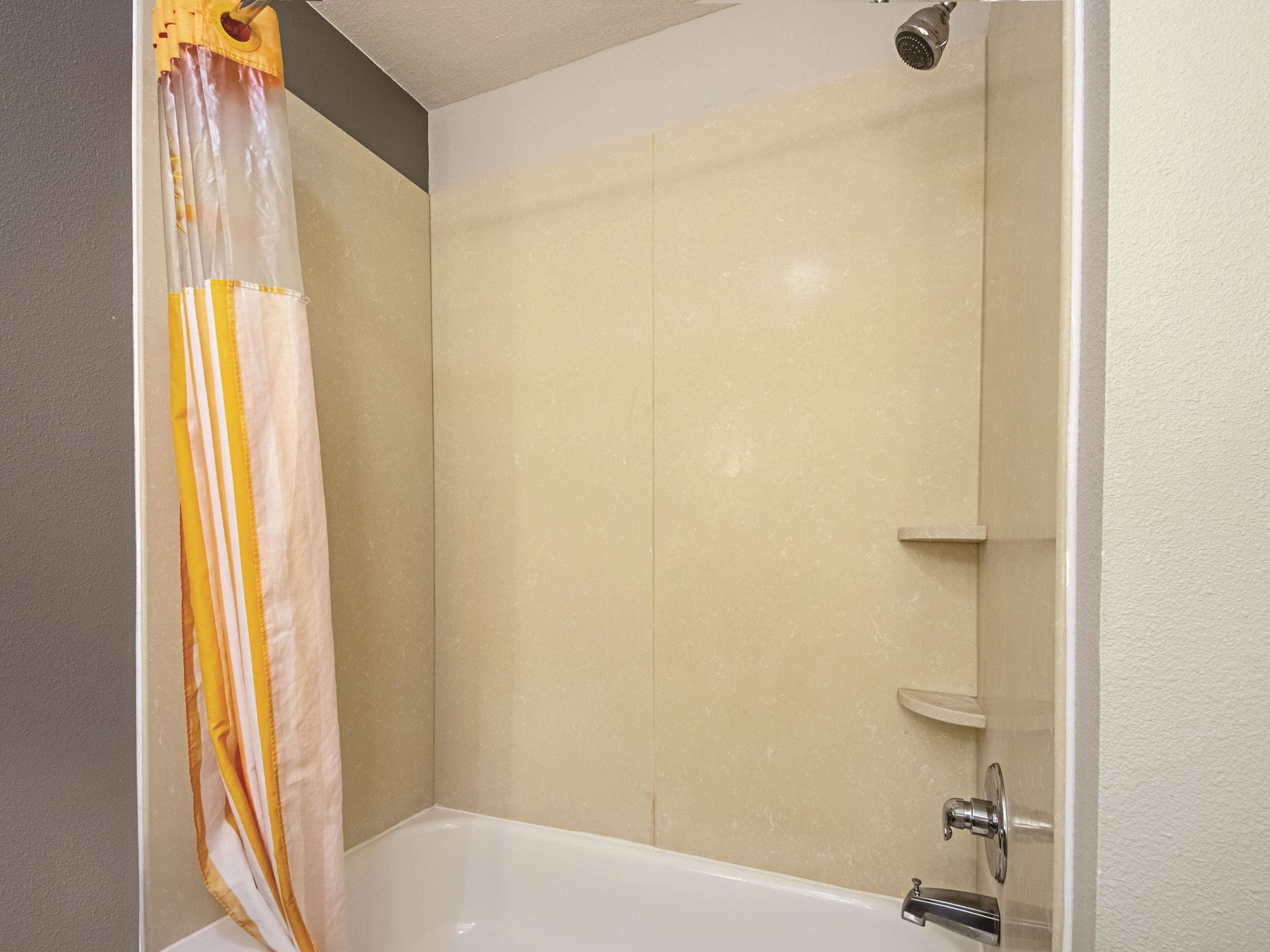 Une salle de bain avec une douche, une baignoire et des toilettes.