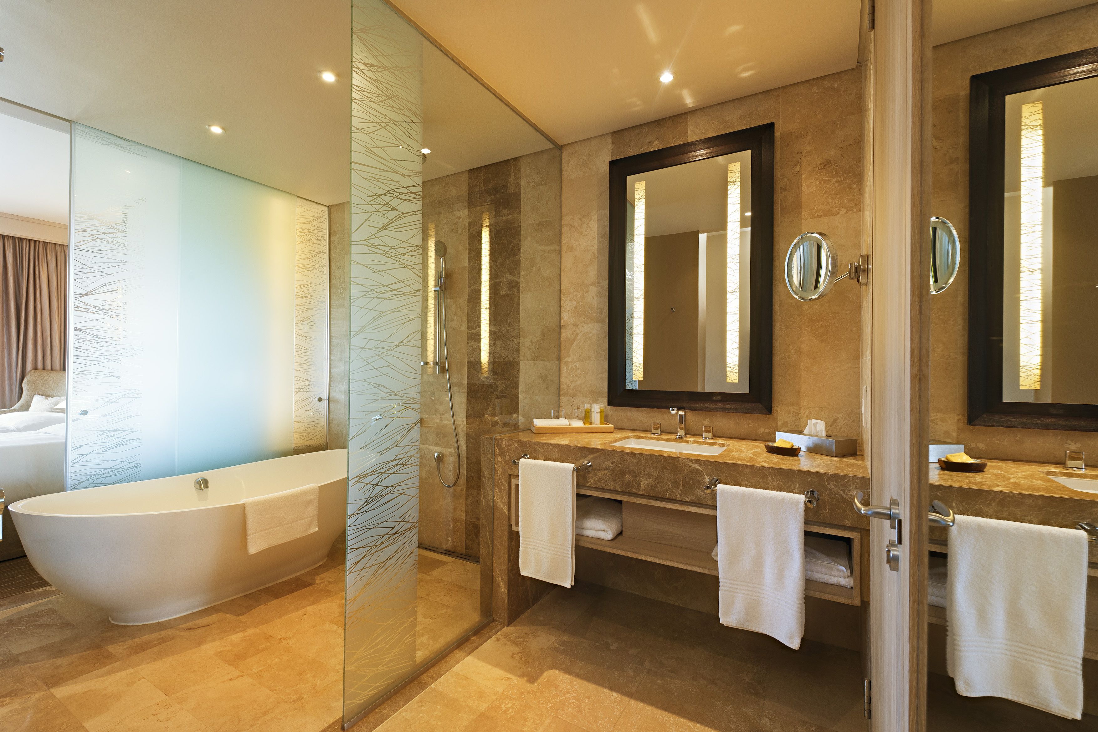 A modern bathroom with a freestanding bathtub, a glass-enclosed shower, and a vanity with two sinks.