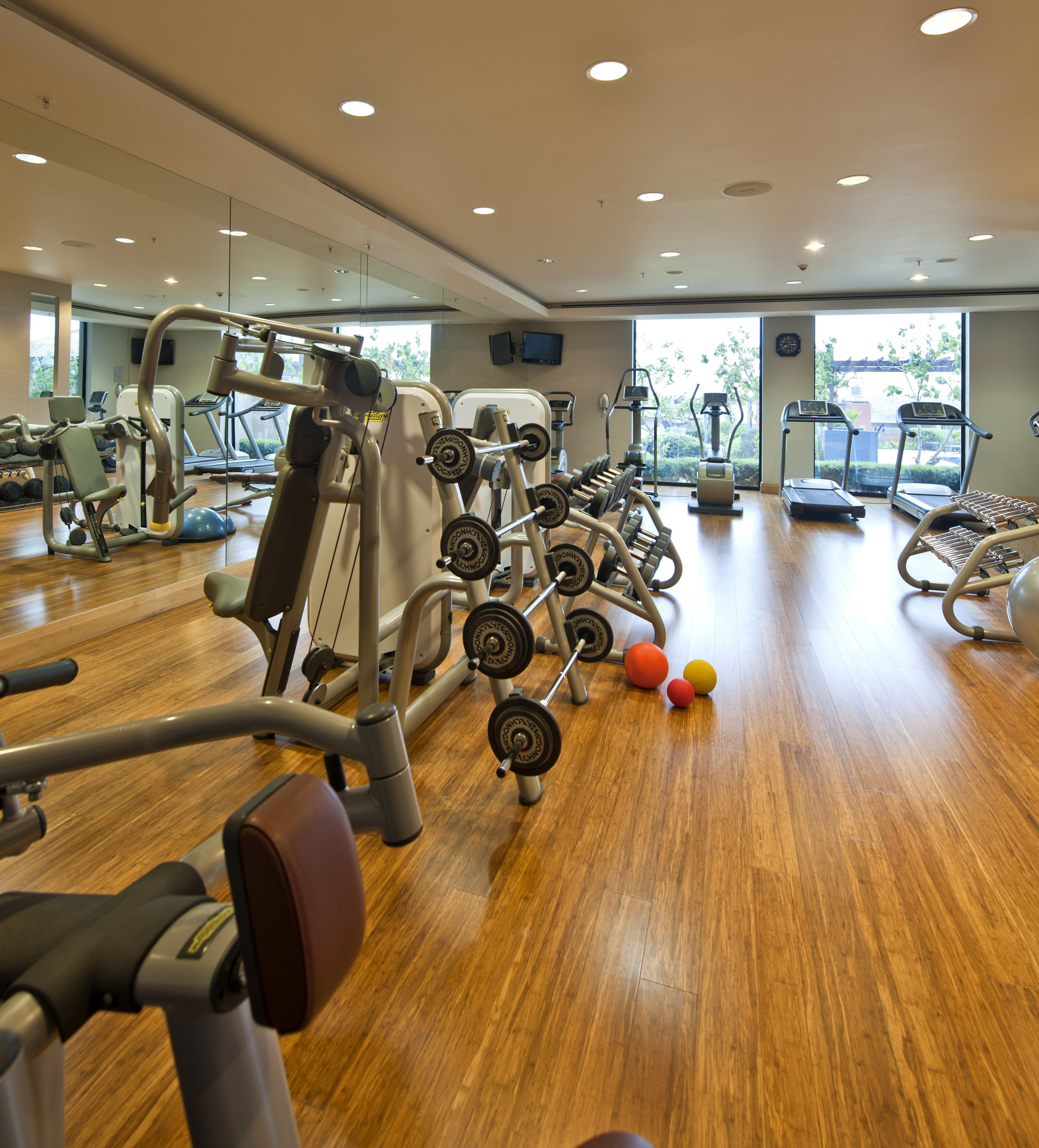 A gym with various exercise equipment, including treadmills, weight machines, and free weights.