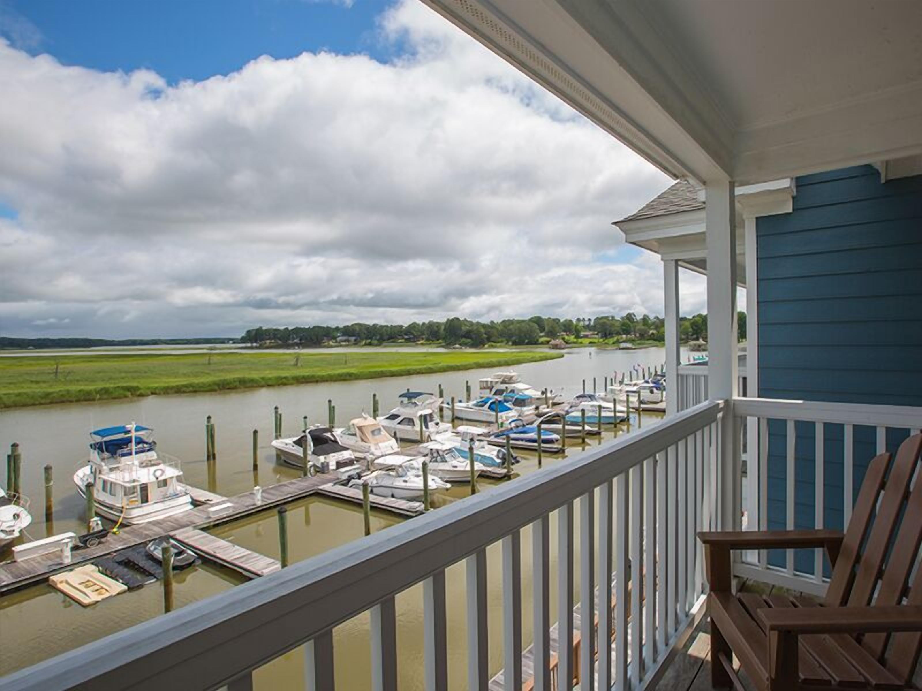 A balcony with a view of a marina and a river.