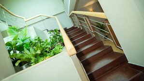 A staircase with wooden steps and metal railings, surrounded by green plants. - Riverview Cambodia Boutique Hotel (Phnom Penh)