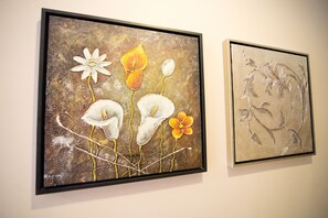 Zwei gerahmte Kunstwerke an einer Wand.
