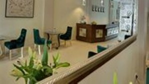 A hotel room with a large mirror, a desk, and two chairs. - Riverview Cambodia Boutique Hotel (Phnom Penh)