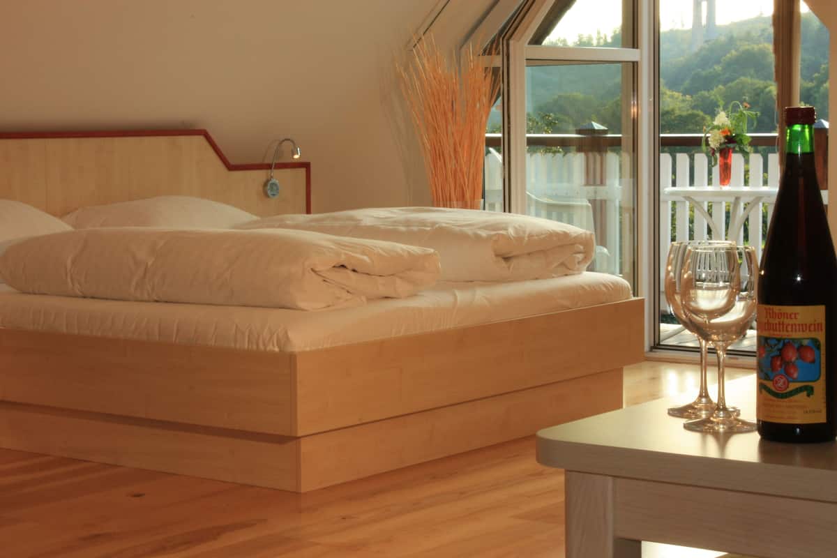 Ein Schlafzimmer mit einem Bett, einer Weinflasche und einem Glas auf einem Tisch.