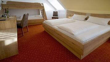 A room with a large bed, a desk, and a bunk bed.