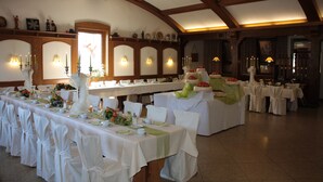 A banquet hall with long tables set for a formal event, featuring white tablecloths, chairs, and floral centerpieces. - Gasthof zum Biber (Motten)