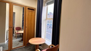 A room with a round table and two chairs, a mirror, and a window with curtains. - Throstles Nest Hotel (Liverpool)