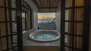 A hot tub with a view of the sunset over the ocean, surrounded by a wooden pergola and traditional lattice doors. - Hotel Pousada Natureza (Cairu)